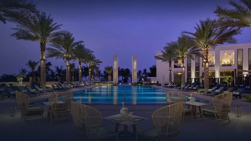 Residences pool and palm gardens at dusk, Mandarin Oriental, Muscat